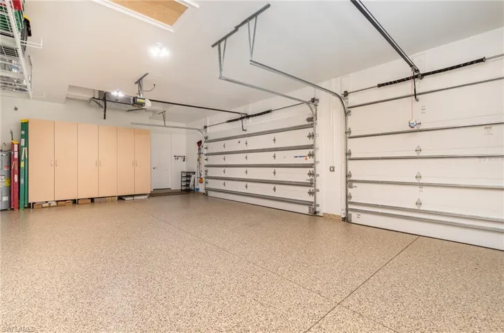 Garage has custom flooring & cabinetry by Encore Garage and Clopay impact garage doors.