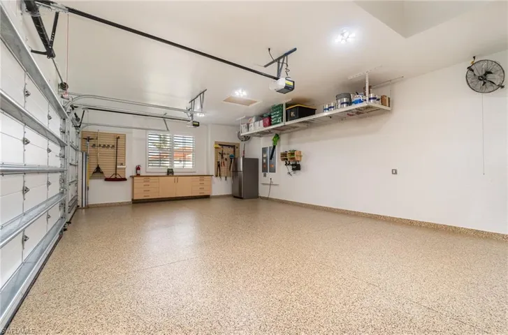 Garage has custom flooring & cabinetry by Encore Garage and Clopay impact garage doors.