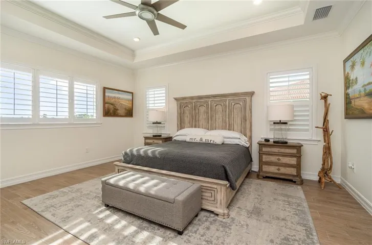 Primary bedroom with ceiling fan, crown molding, and tiled flooring