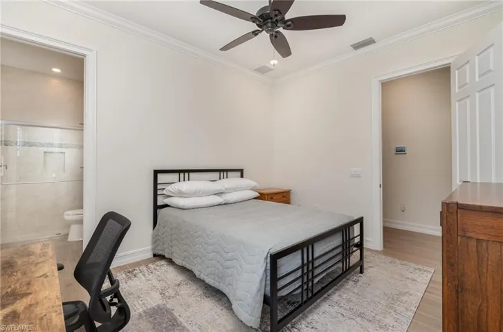 ENSUITE Bedroom with tile flooring, ensuite bathroom, ceiling fan, and crown molding