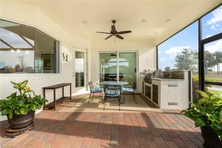 Screened Lanai hot tub, outdoor kitchen, sitting area, golf views, water features with ceiling fan