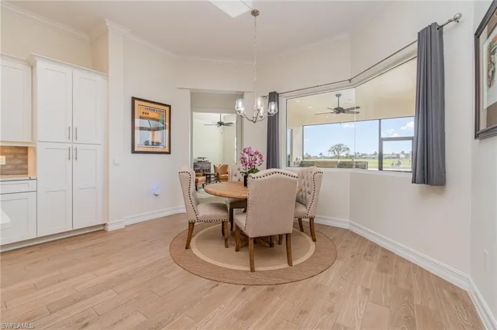 Dining space with a chandelier, tiled floors, and crown molding