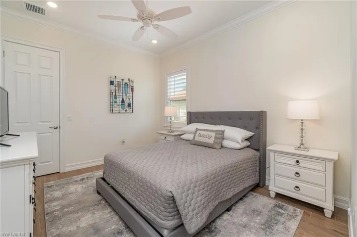 Bedroom with tiled floors, ceiling fan, and crown molding
