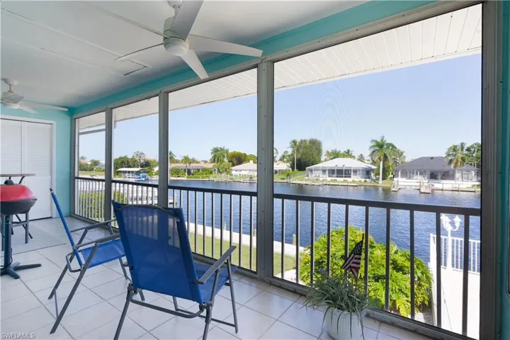 Sunroom / solarium with a water view, tile patterned floors, and a residential view