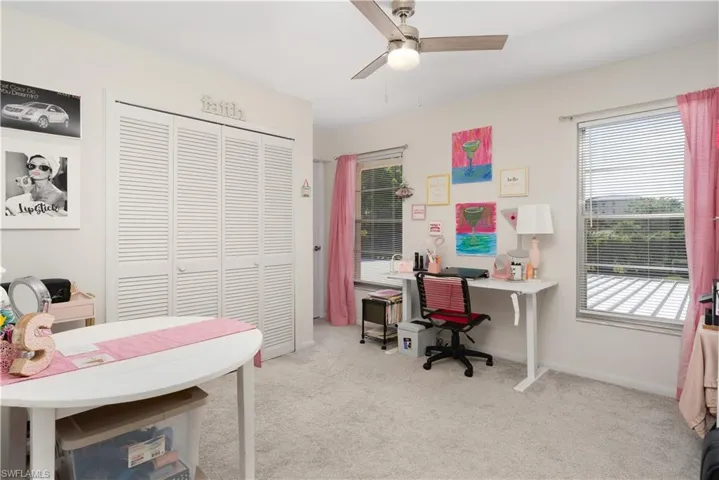 Office area featuring light carpet and ceiling fan