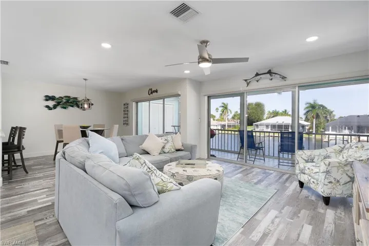 Living room featuring recessed lighting, a water view, light wood finished floors, and a ceiling fan