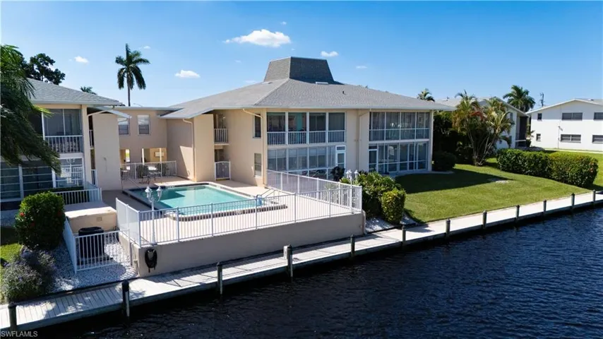 Rear view of property featuring a community pool, a patio area, and stucco siding