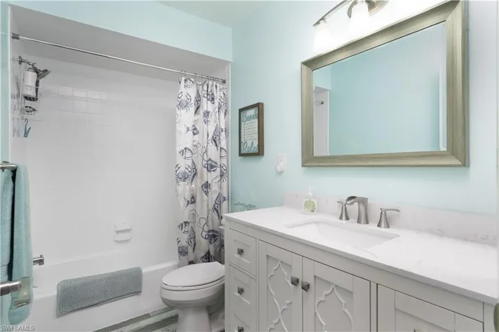 Bathroom with shower / tub combo with curtain and vanity