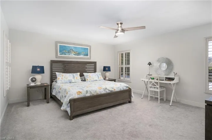 Carpeted bedroom featuring a ceiling fan and baseboards