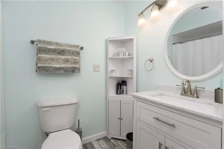 Bathroom with vanity, a shower with curtain, and light wood finished floors