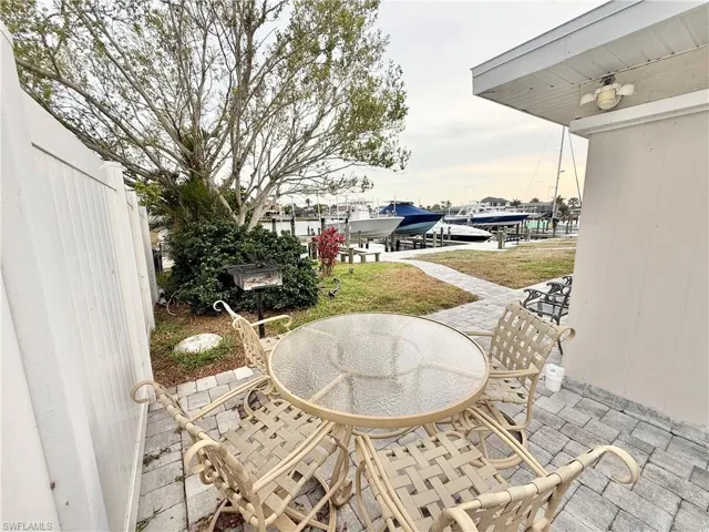 View of patio / terrace featuring boat lift, a boat dock, a water view, and outdoor dining area
