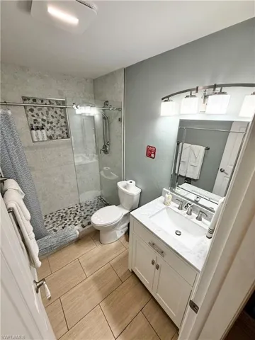 Full bathroom with a stall shower, vanity, and toilet