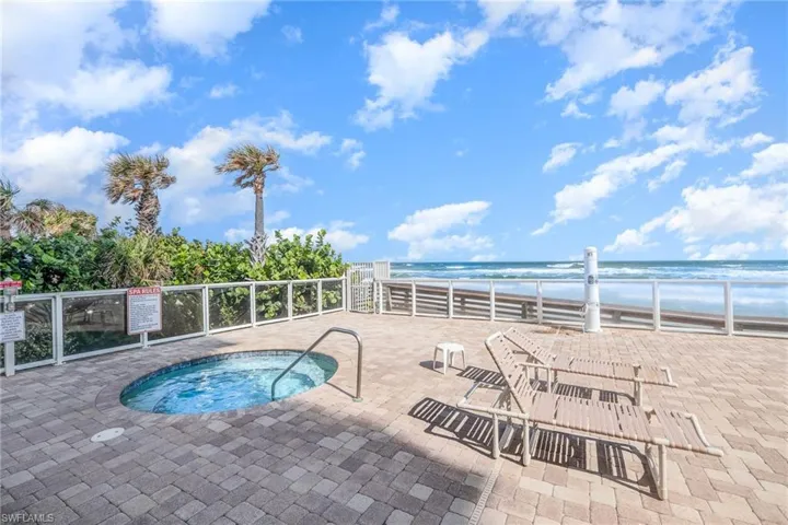View of pool featuring a hot tub and a water view