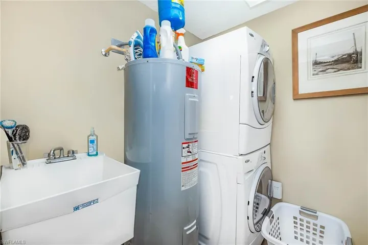 Laundry area with water heater and estacked washer and dryer