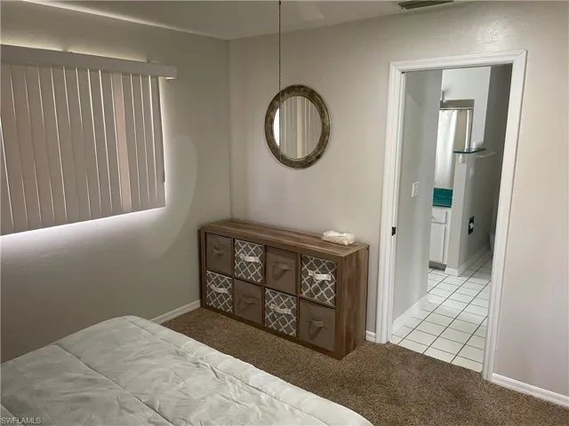 Bedroom with light colored carpet and baseboards