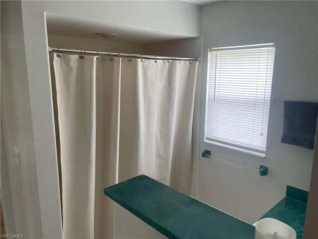 Full bath with curtained shower and vanity