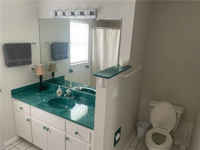 Bathroom with vanity, a shower with shower curtain, and light tile patterned floors