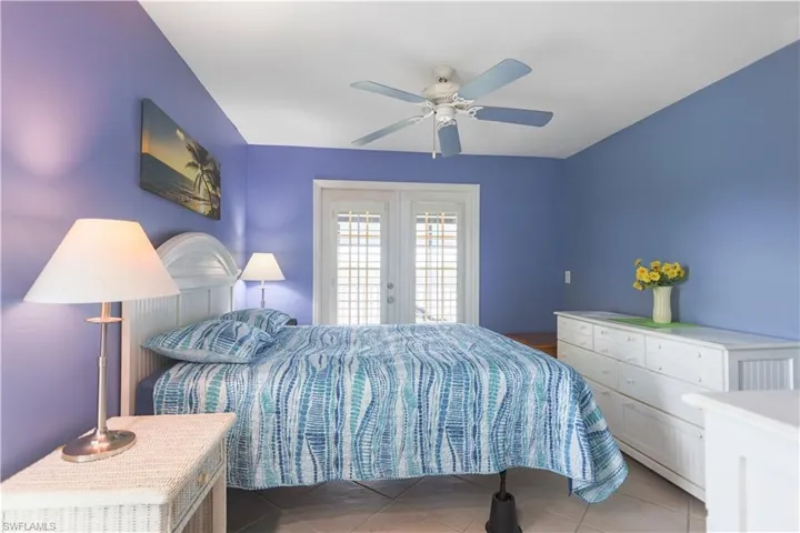 Tiled bedroom featuring ceiling fan