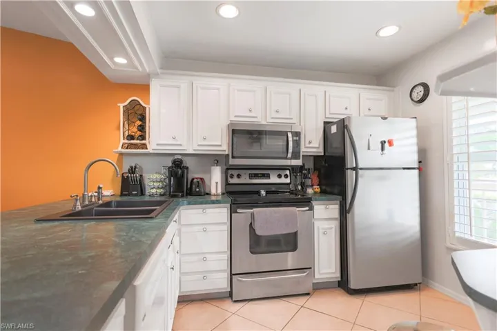 Kitchen featuring white cabinets, appliances with stainless steel finishes, sink, and a wealth of natural light