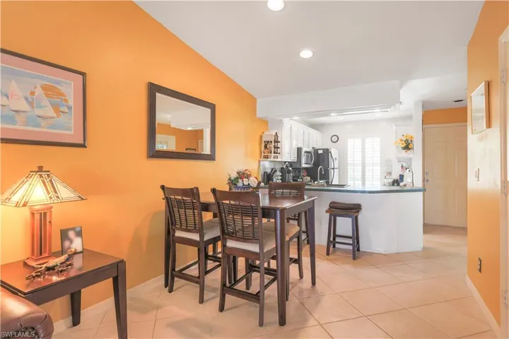 Tiled dining area with lofted ceiling