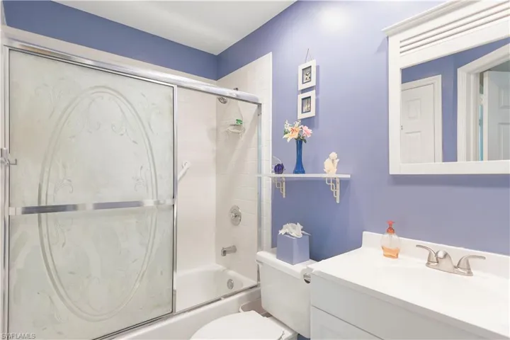 Full bathroom with vanity, toilet, and combined bath / shower with glass door