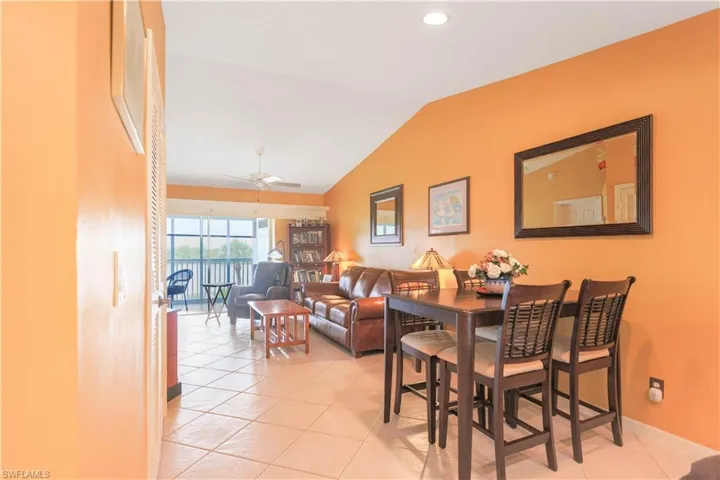 Dining area with ceiling fan, lofted ceiling, and light tile patterned floors