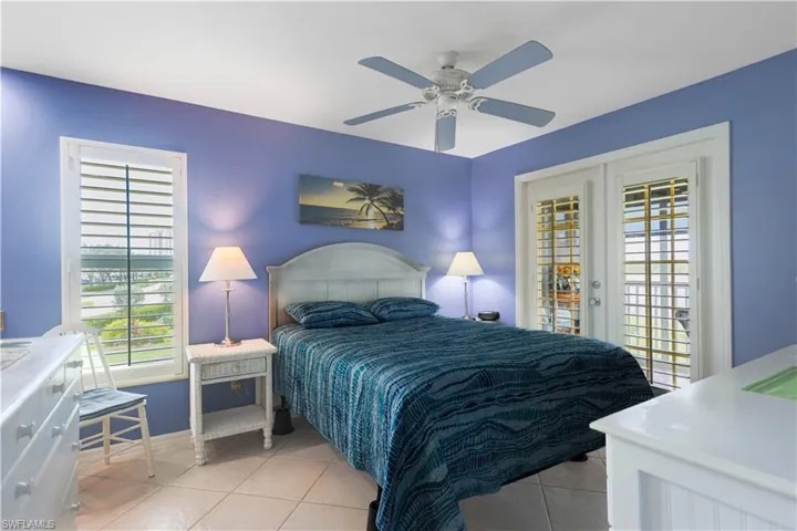 Tiled bedroom featuring ceiling fan, french doors, and access to exterior