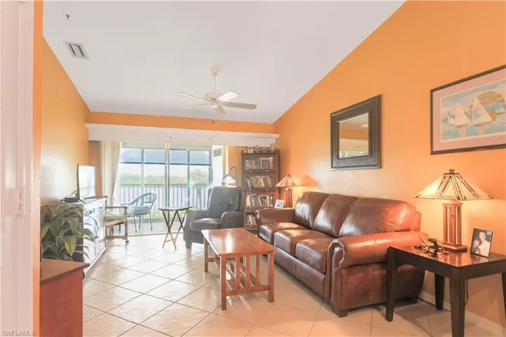 Tiled living room with vaulted ceiling and ceiling fan