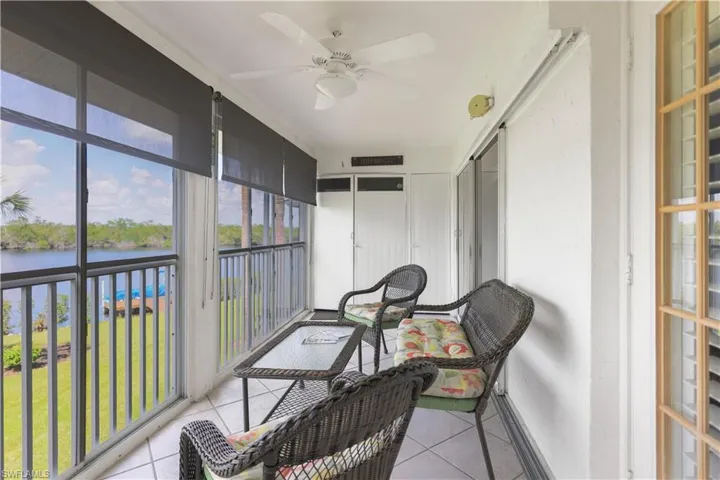 Sunroom / solarium with ceiling fan and a water view