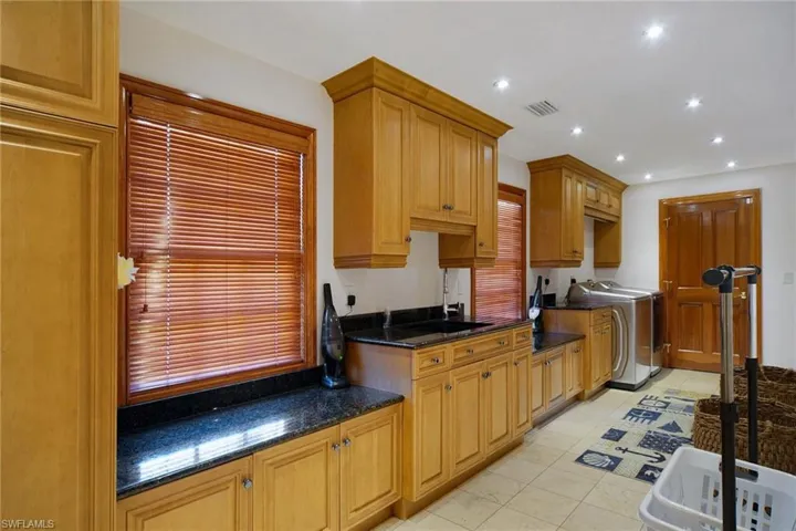 Plethora of cabinets & counter space in this massive Laundry room with adjoining half bath off Kitchen