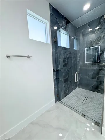 Full bath featuring baseboards and a marble finish shower