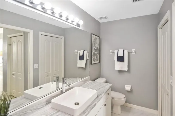Bathroom with vanity and a closet