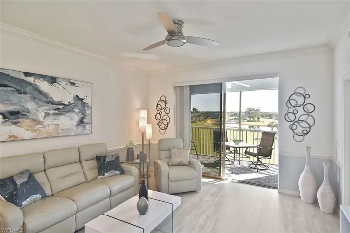 Living area featuring wood finished floors, ornamental molding, and ceiling fan