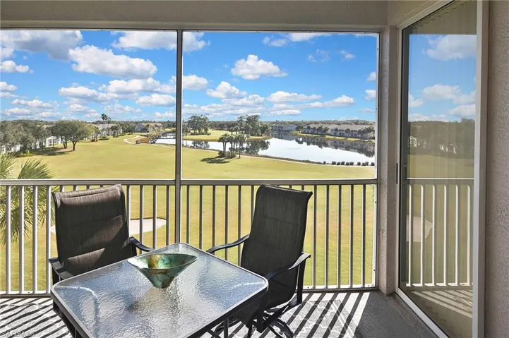 Sunroom with a water view and view of golf course