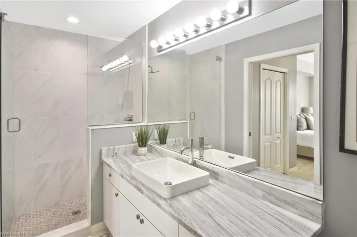 Full bath featuring a stall shower, vanity, and ensuite bathroom