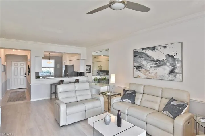 Living area with ceiling fan, crown molding, and wood finished floors