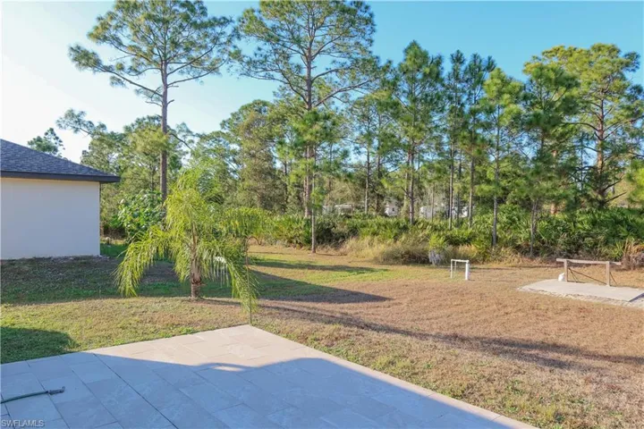 View of grassy yard featuring a patio area