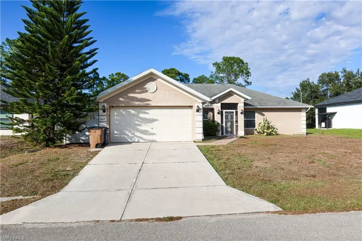 Single story home with stucco siding, a front yard, concrete driveway, and an attached garage