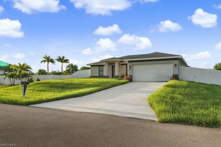 Ranch-style house with stucco siding, driveway, and a garage