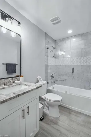 Full bathroom featuring combined bath / shower with glass door and vanity