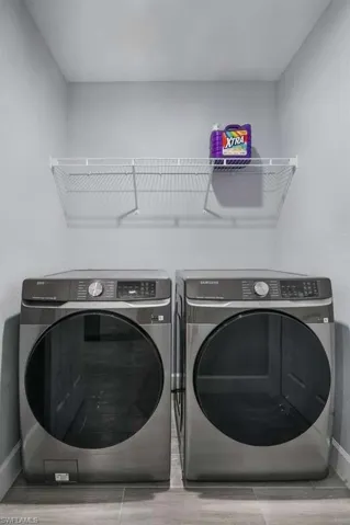 Laundry area with baseboards and washer and dryer