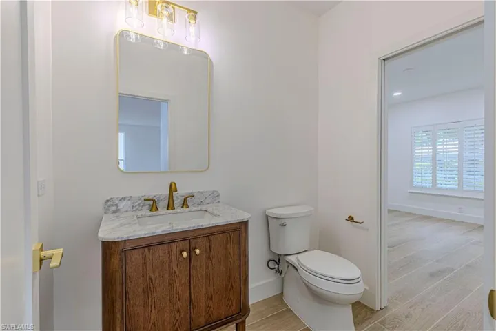 Powder Bathroom with vanity and wood finished floors