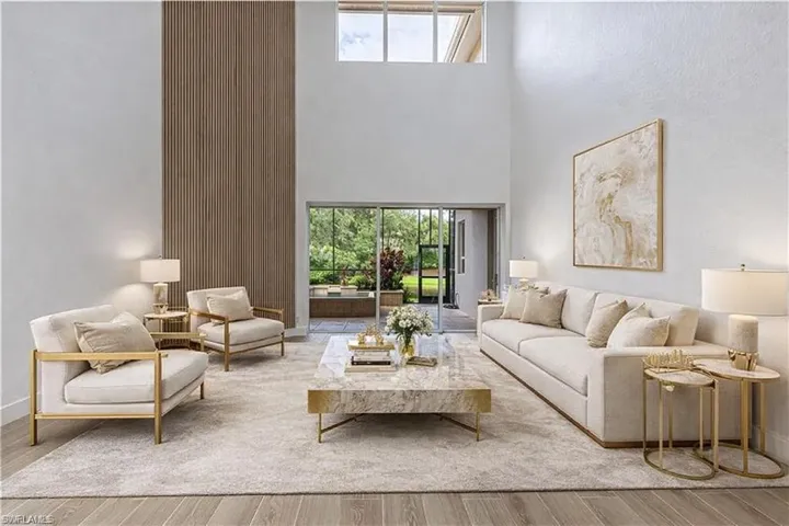Living room featuring healthy amount of natural light, wood finished floors, and a high ceiling