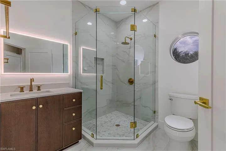 Guest Full bathroom featuring marble finish flooring, a marble finish shower, and vanity