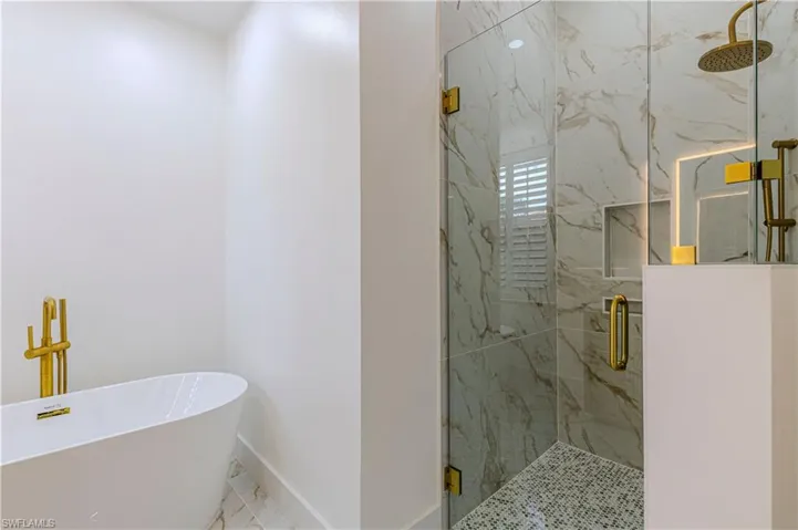 Primary Full bath with a freestanding tub, marble finish flooring, and a marble finish shower