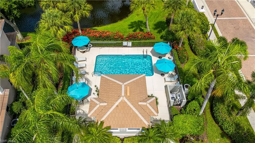 Aerial view of property featuring community pool directly next door with water view