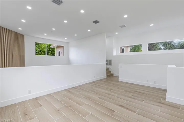 Bonus Spare room with recessed lighting, light wood-style floors, and stairs