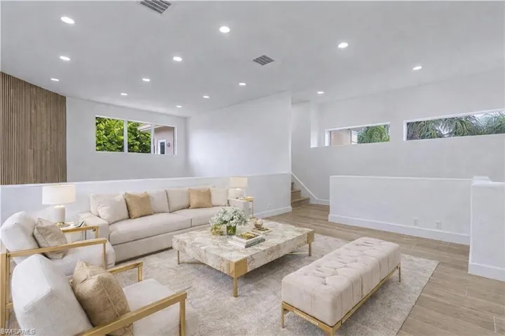 Living area featuring light wood-style floors, recessed lighting, and wood walls