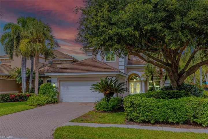Mediterranean / spanish home with an attached garage, decorative driveway, stucco siding, and a tiled roof