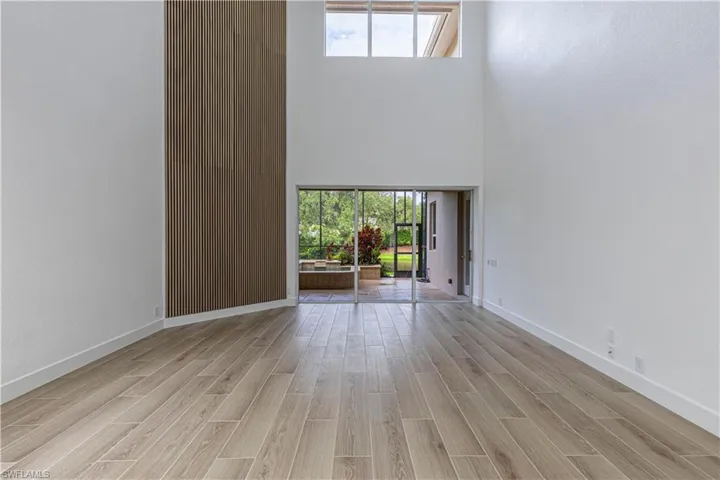 Great Room with light wood-style floors and a towering ceiling